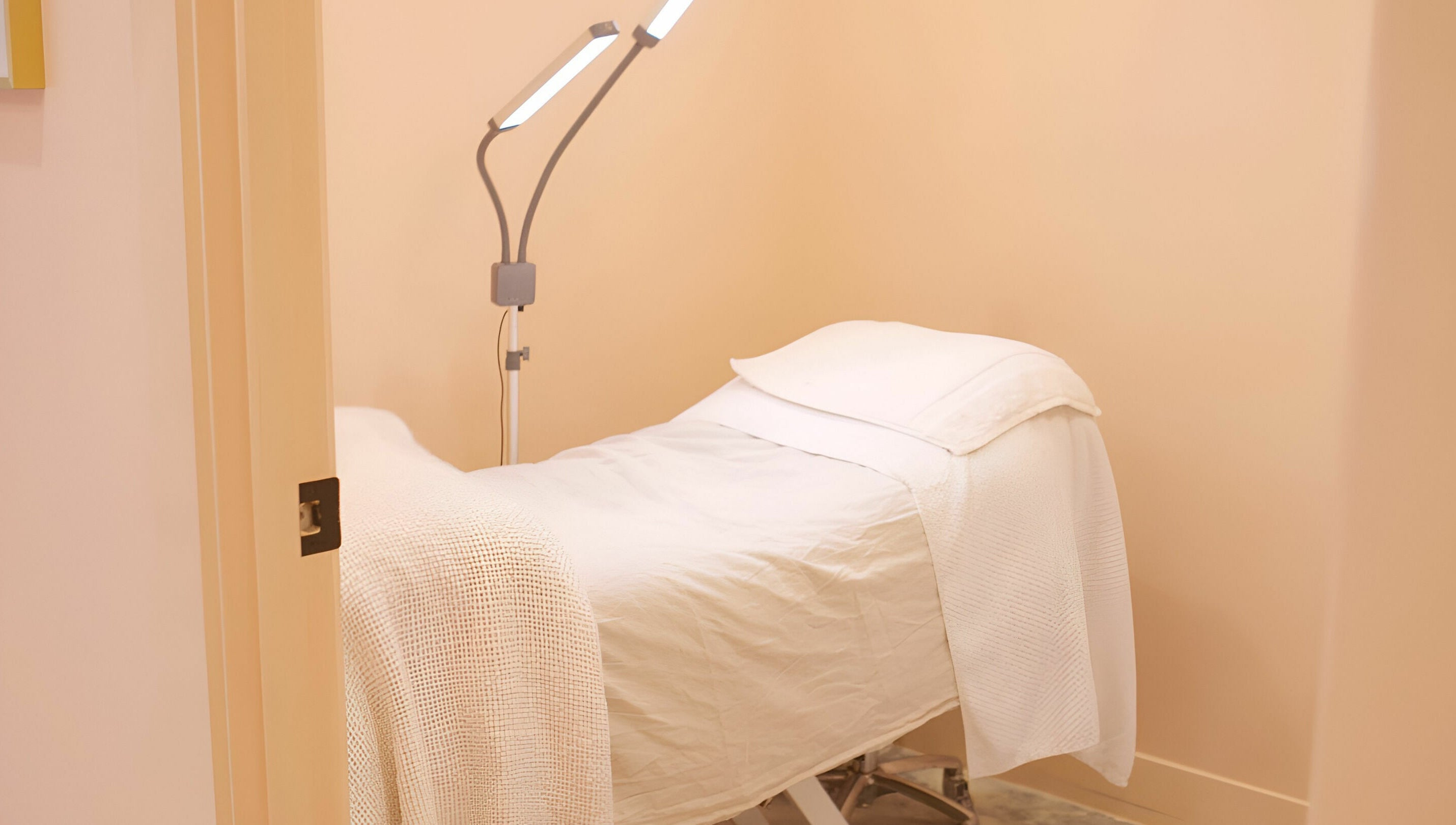 Peaceful treatment room at Wilde Beauty Bar, Bundall, Queensland, AU with a cozy bed and modern lighting.