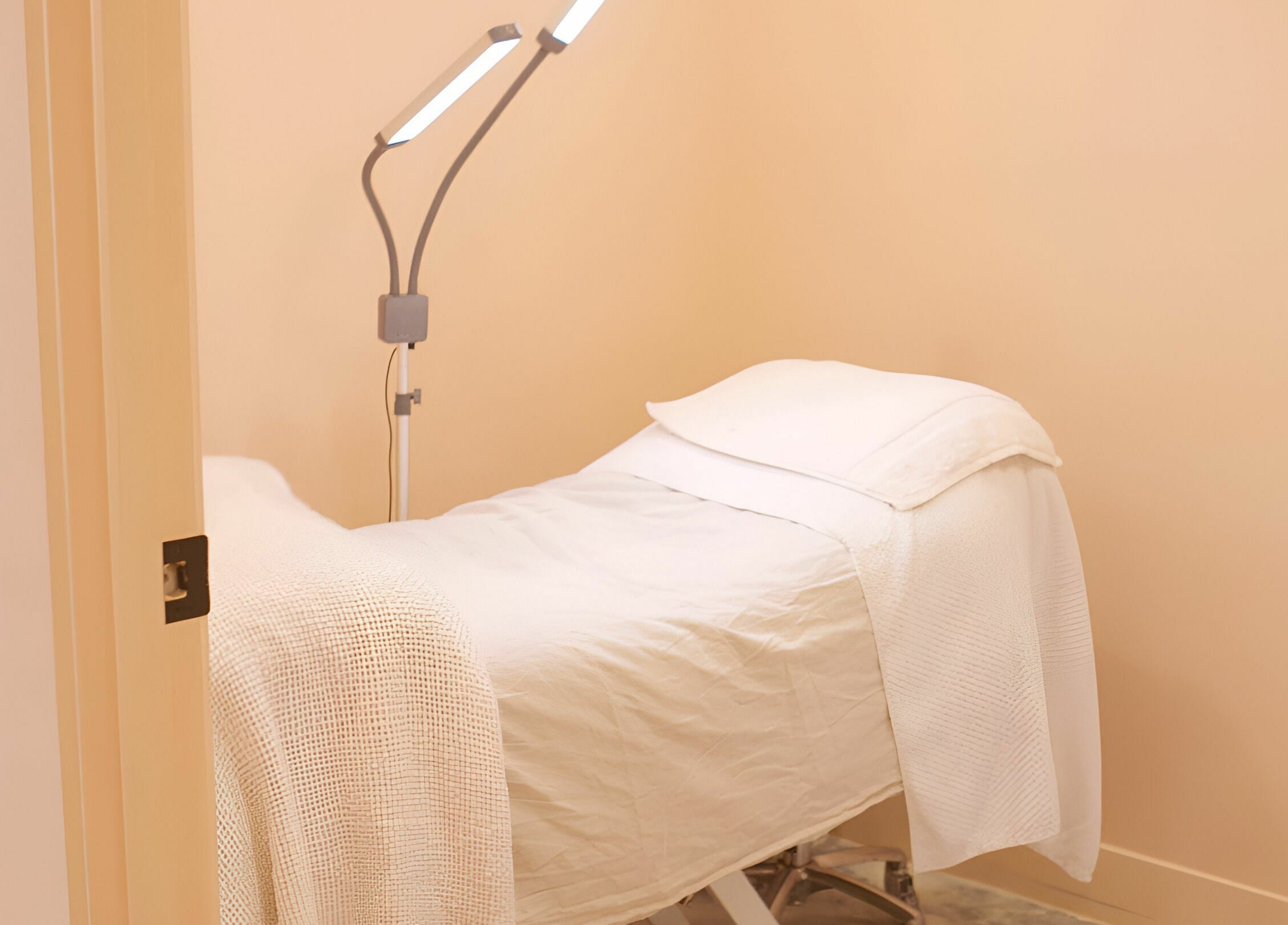 Peaceful treatment room at Wilde Beauty Bar, Bundall, Queensland, AU with a cozy bed and modern lighting.