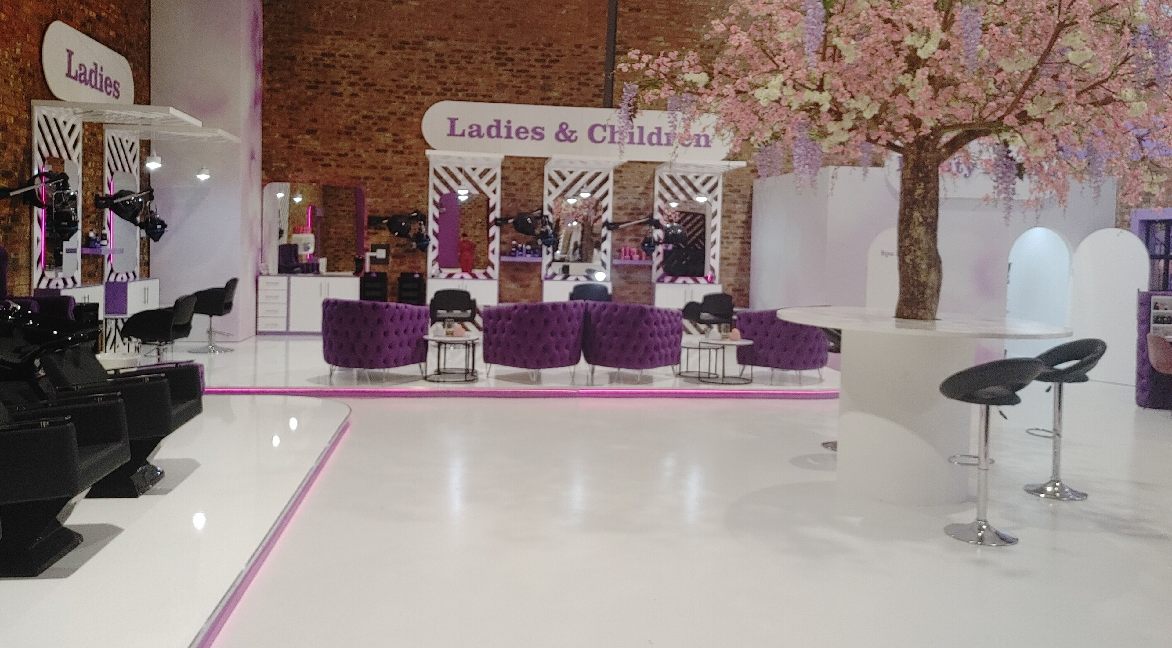 Modern salon interior at Volumicious Riversands, Johannesburg, Gauteng, ZA. Plush seating and elegant decor.