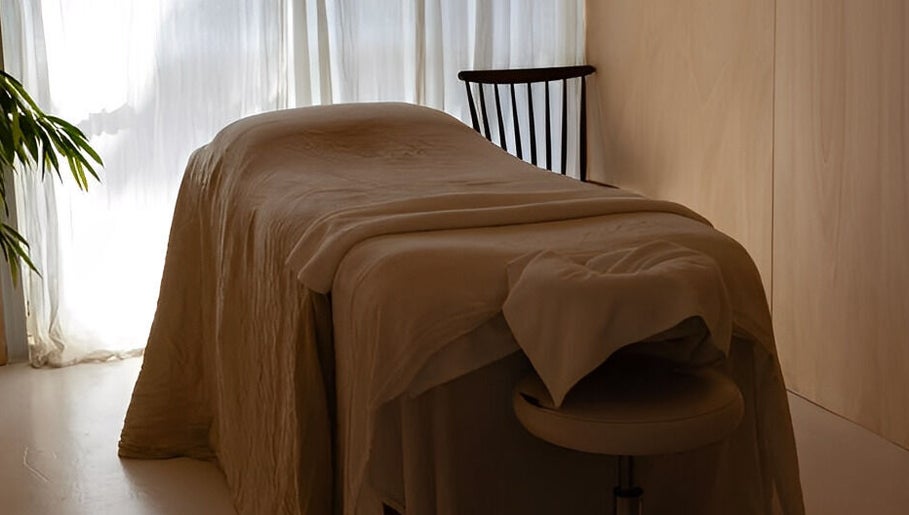 A tranquil massage room at The Calmm, Lovedale, New South Wales, AU with soft lighting and comfy bed.