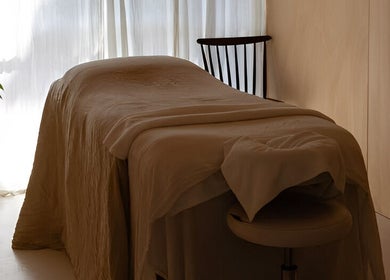 A tranquil massage room at The Calmm, Lovedale, New South Wales, AU with soft lighting and comfy bed.