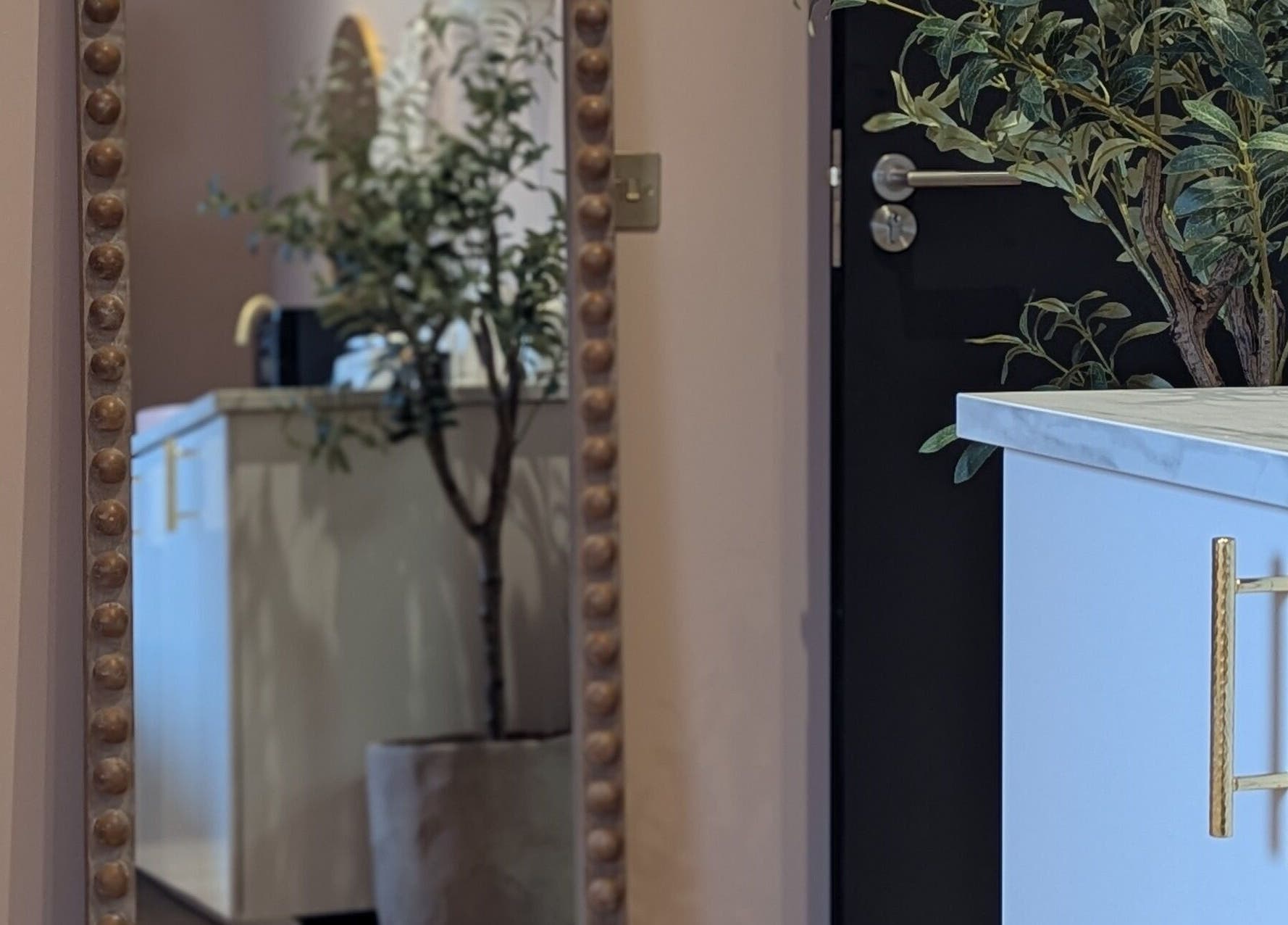 Elegant interior of Glow Studio by Suzanne Wilson, Musselburgh, Scotland, with decorative mirror and plants.