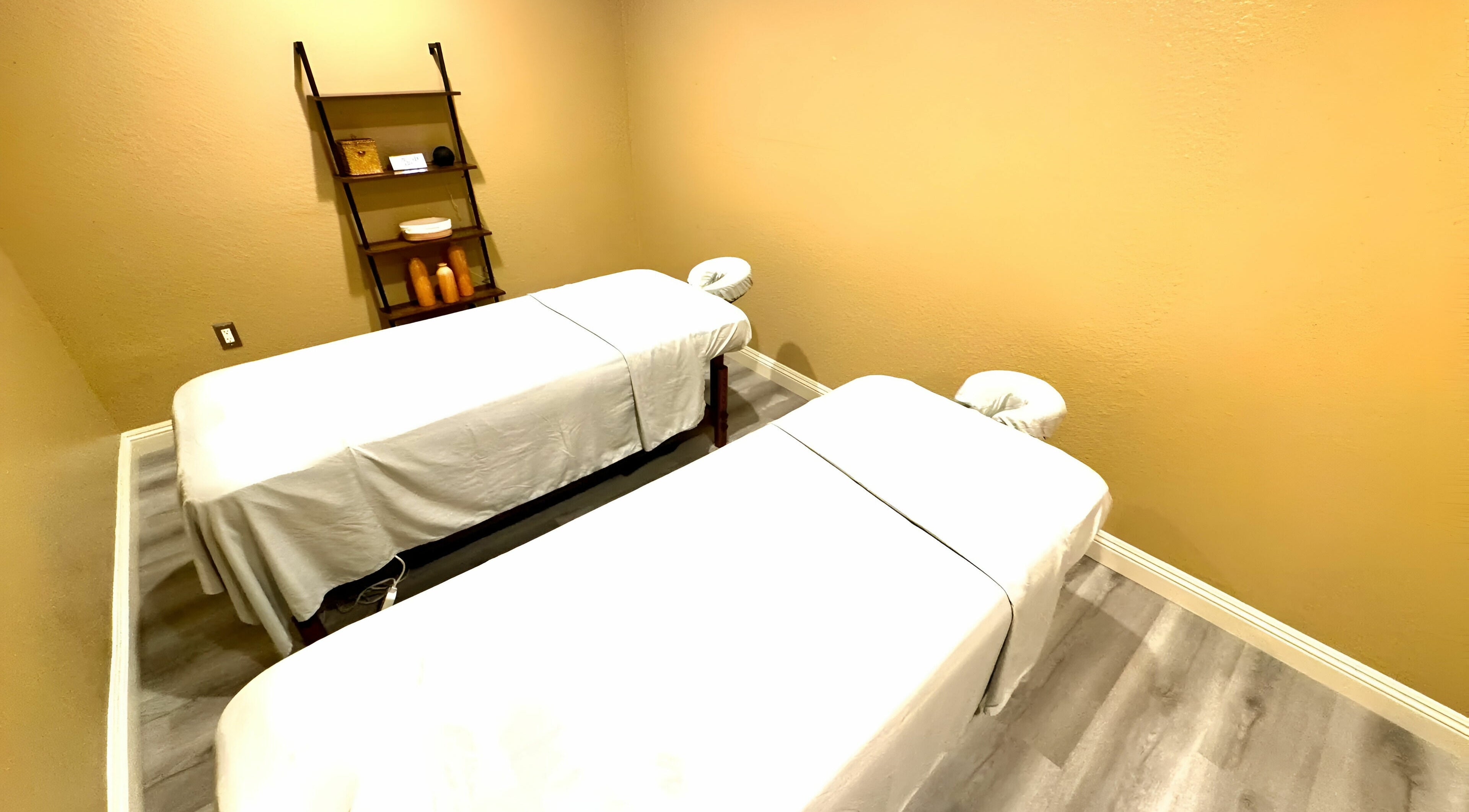 Cozy massage room at The Massage, Torrance, California, US with two beds ready for therapy.