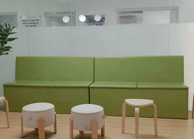 Relaxing waiting area at Skin Clean Dermatology Clinic, Biñan, Calabarzon, PH with green seating and tables.