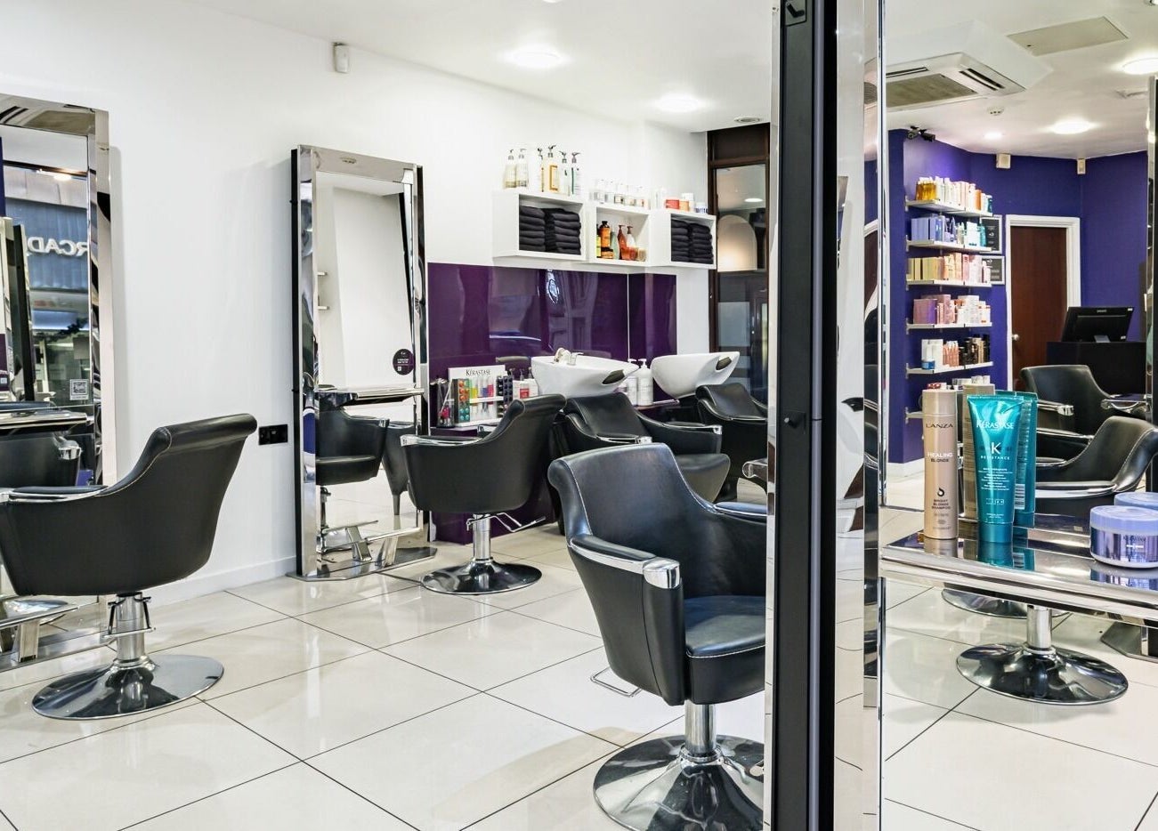 Modern salon setup at Cora Hair, Birmingham, England, GB featuring stylish chairs and product display.