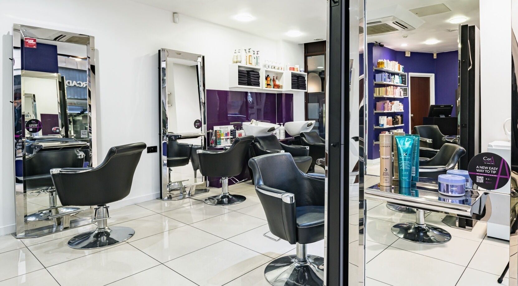 Modern salon setup at Cora Hair, Birmingham, England, GB featuring stylish chairs and product display.