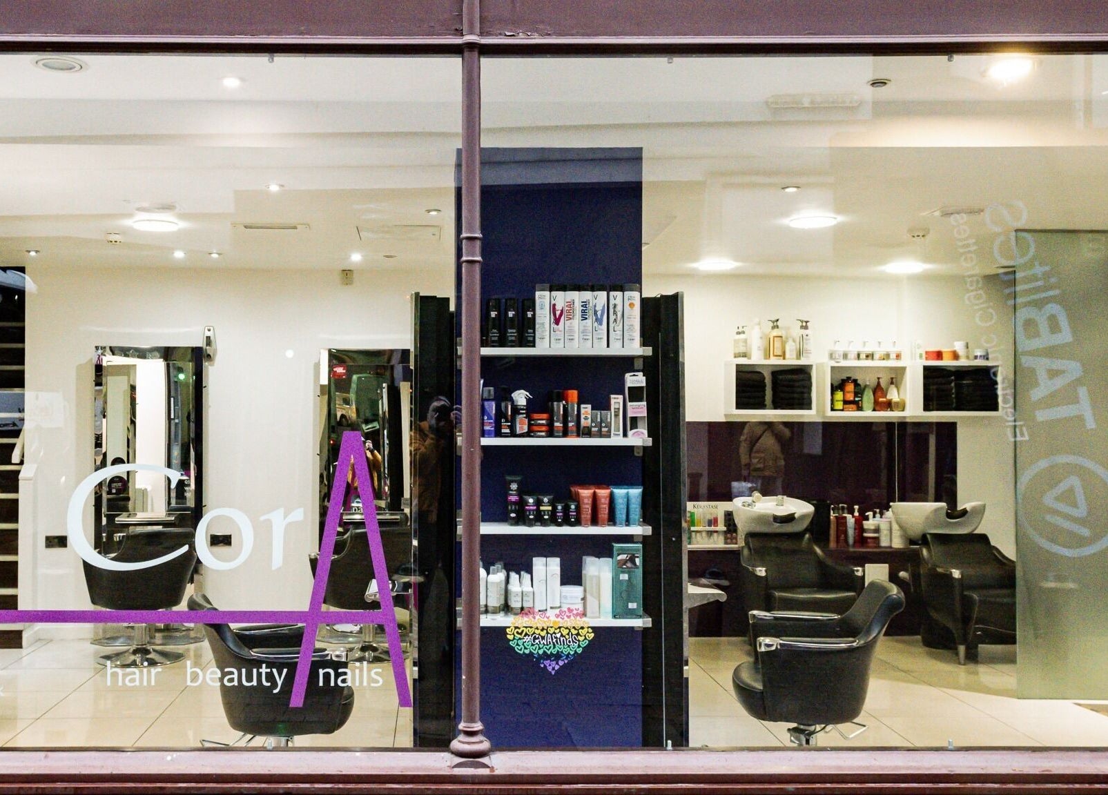 Elegant salon view of Cora Hair in Birmingham, England, GB displays modern interior and products.