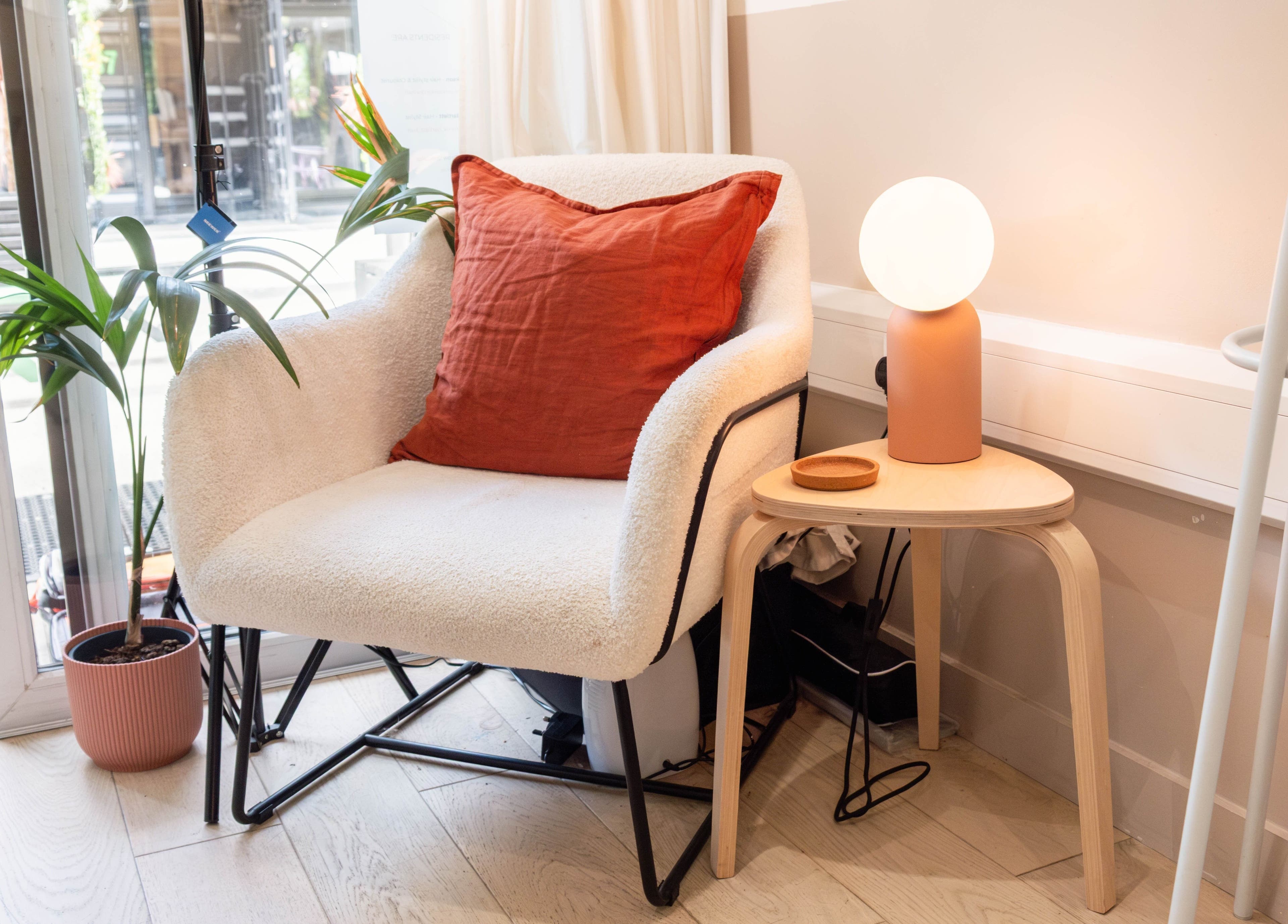 Elegant seating area at Home of Cole Jackson, London, England, GB, featuring a plush chair and soft lighting.
