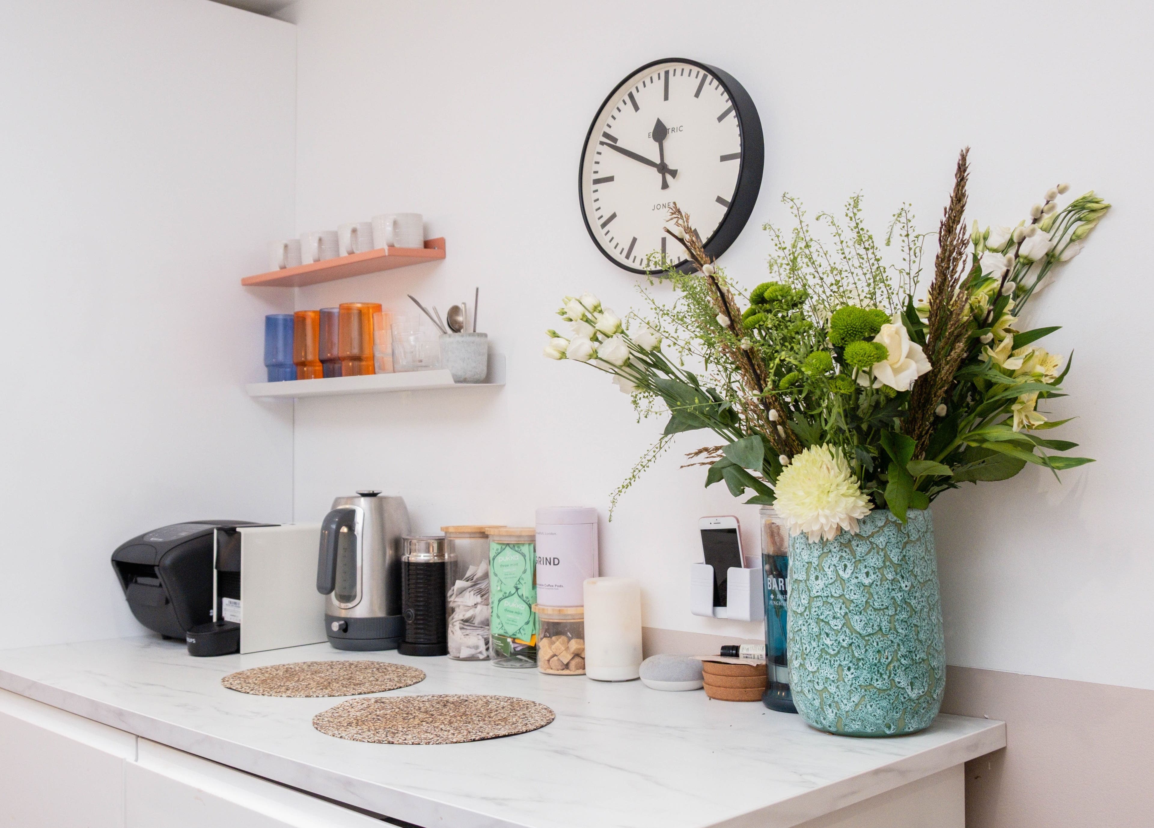 Stylish kitchen corner at Home of Cole Jackson, London, England, GB featuring a floral vase and kettle.