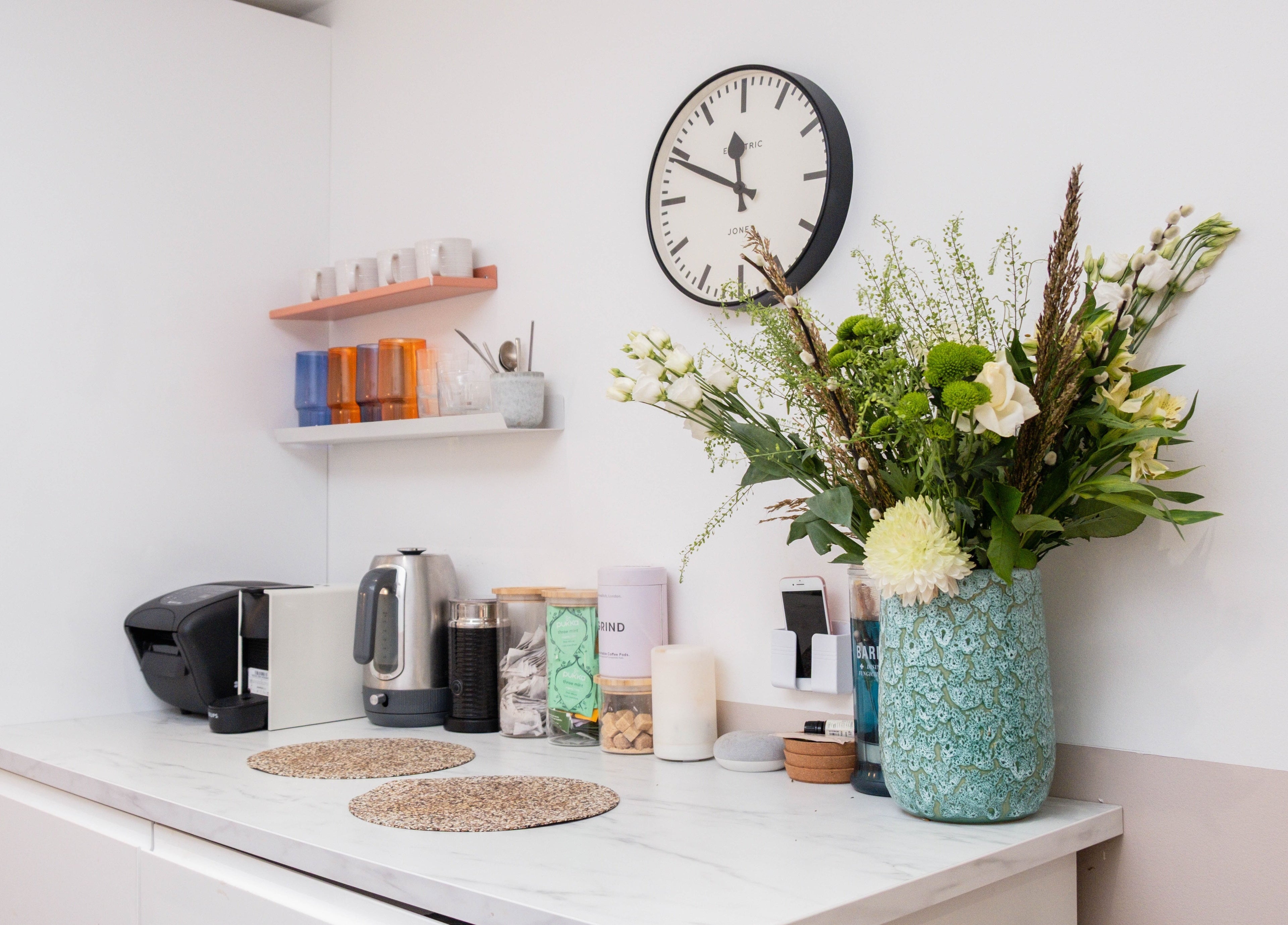 Stylish kitchen corner at Home of Cole Jackson, London, England, GB featuring a floral vase and kettle.