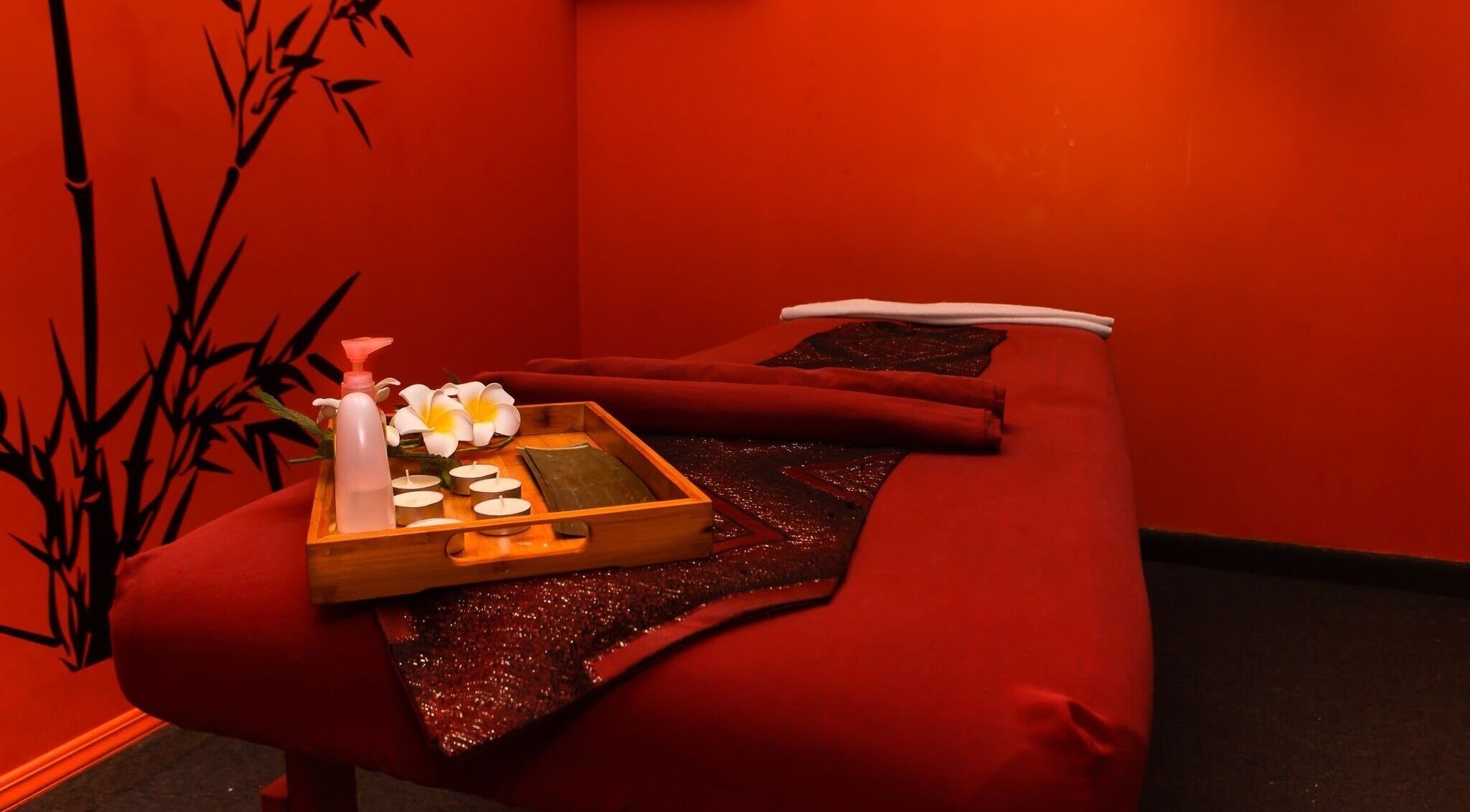 Tranquil therapy room at Bamboo Spa Onehunga, Auckland, Auckland, NZ with red decor and bamboo accents.