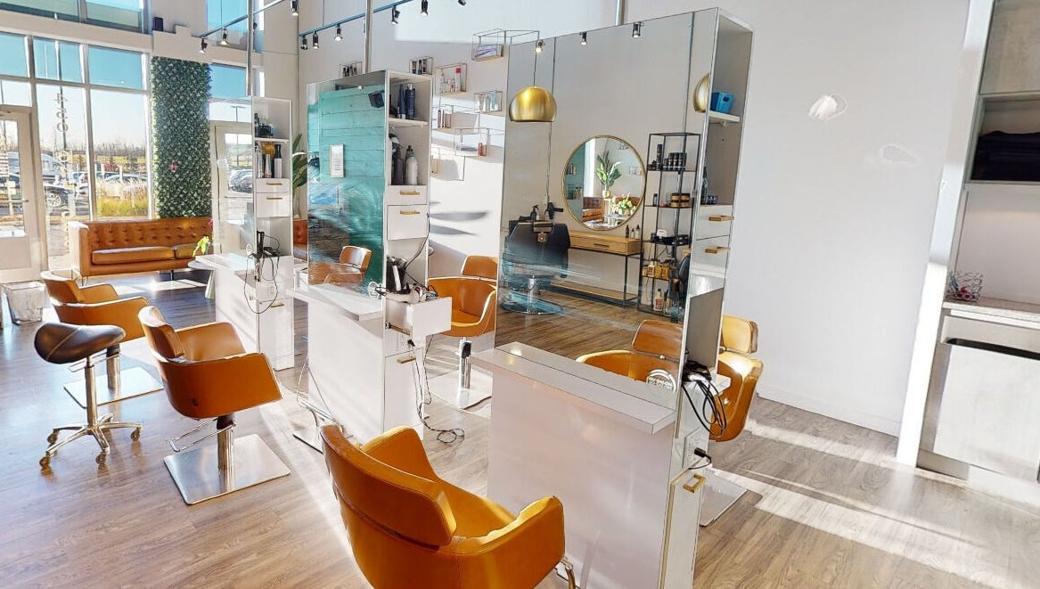 Intérieur lumineux de Coiffure LaShop Design à Boucherville, Québec, CA avec chaises modernes et miroirs élégants.