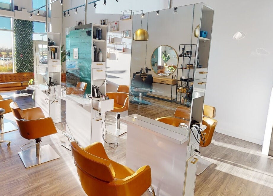 Intérieur lumineux de Coiffure LaShop Design à Boucherville, Québec, CA avec chaises modernes et miroirs élégants.