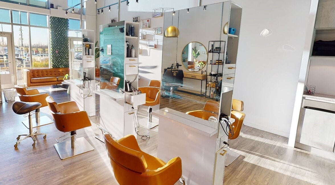 Intérieur lumineux de Coiffure LaShop Design à Boucherville, Québec, CA avec chaises modernes et miroirs élégants.