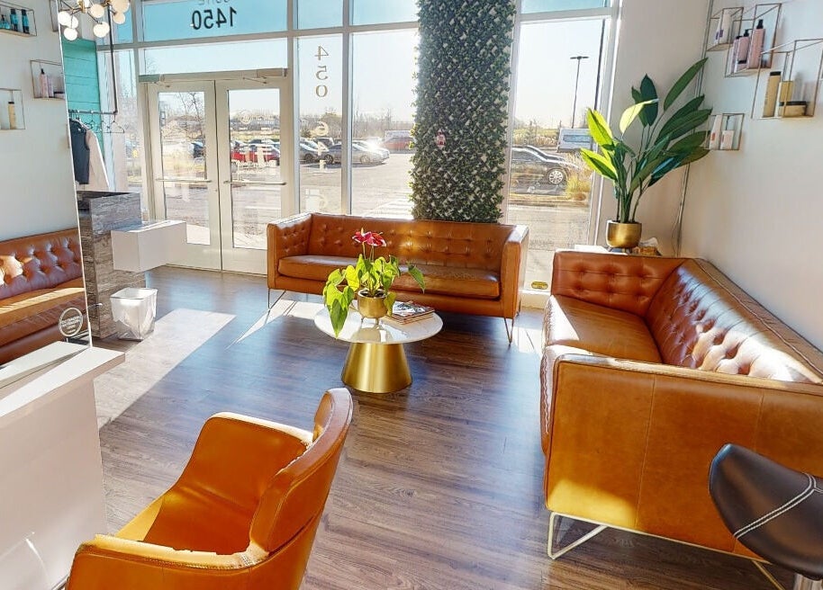 Intérieur lumineux de Coiffure LaShop Design à Boucherville, Québec, CA, avec canapé en cuir.