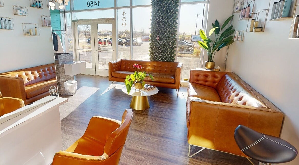 Intérieur lumineux de Coiffure LaShop Design à Boucherville, Québec, CA, avec canapé en cuir.