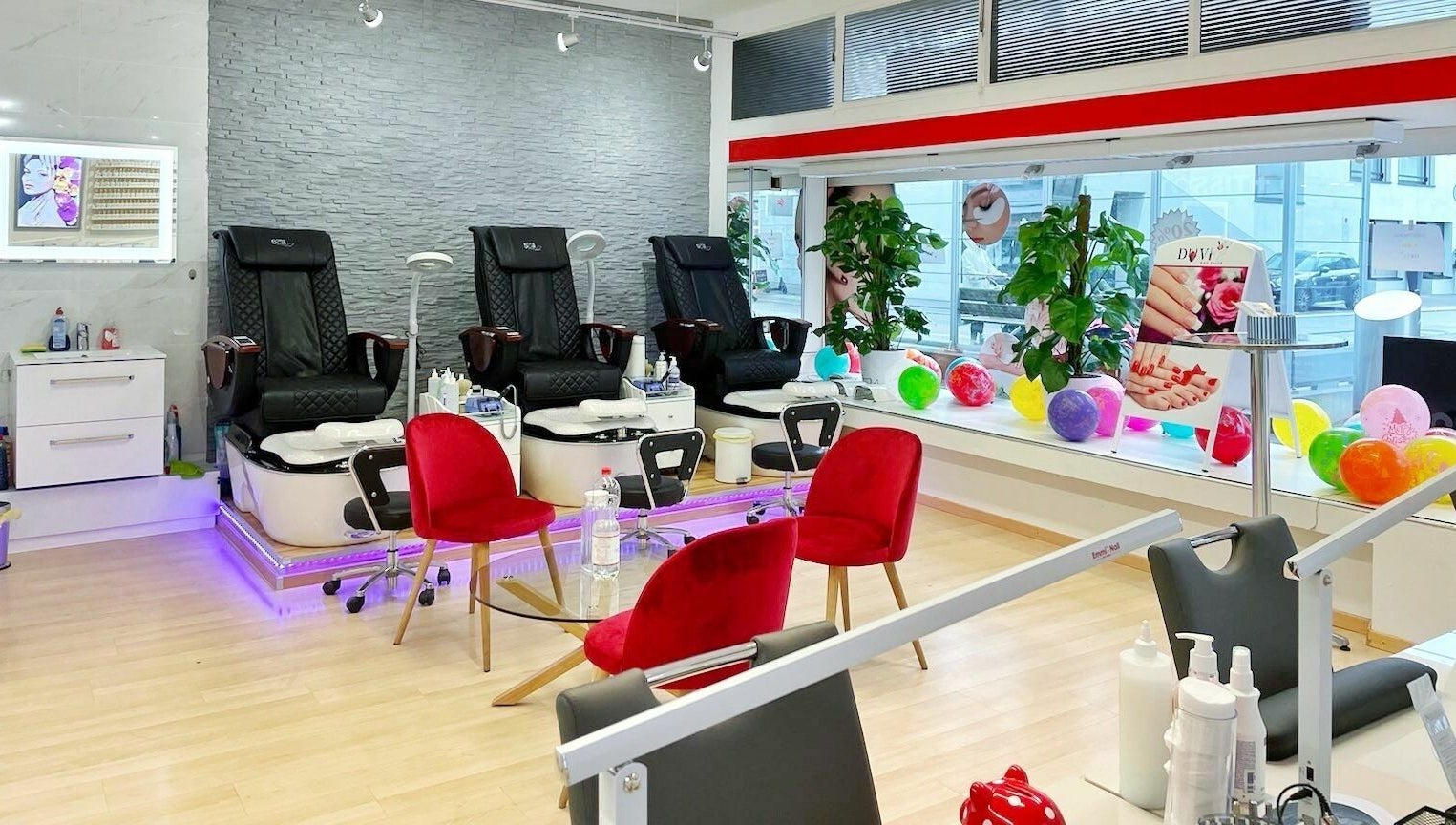 Bright interior of Duvi Nails Salon - Zurich showcases luxurious nail spa chairs and red accents, Zürich, Zürich, CH.