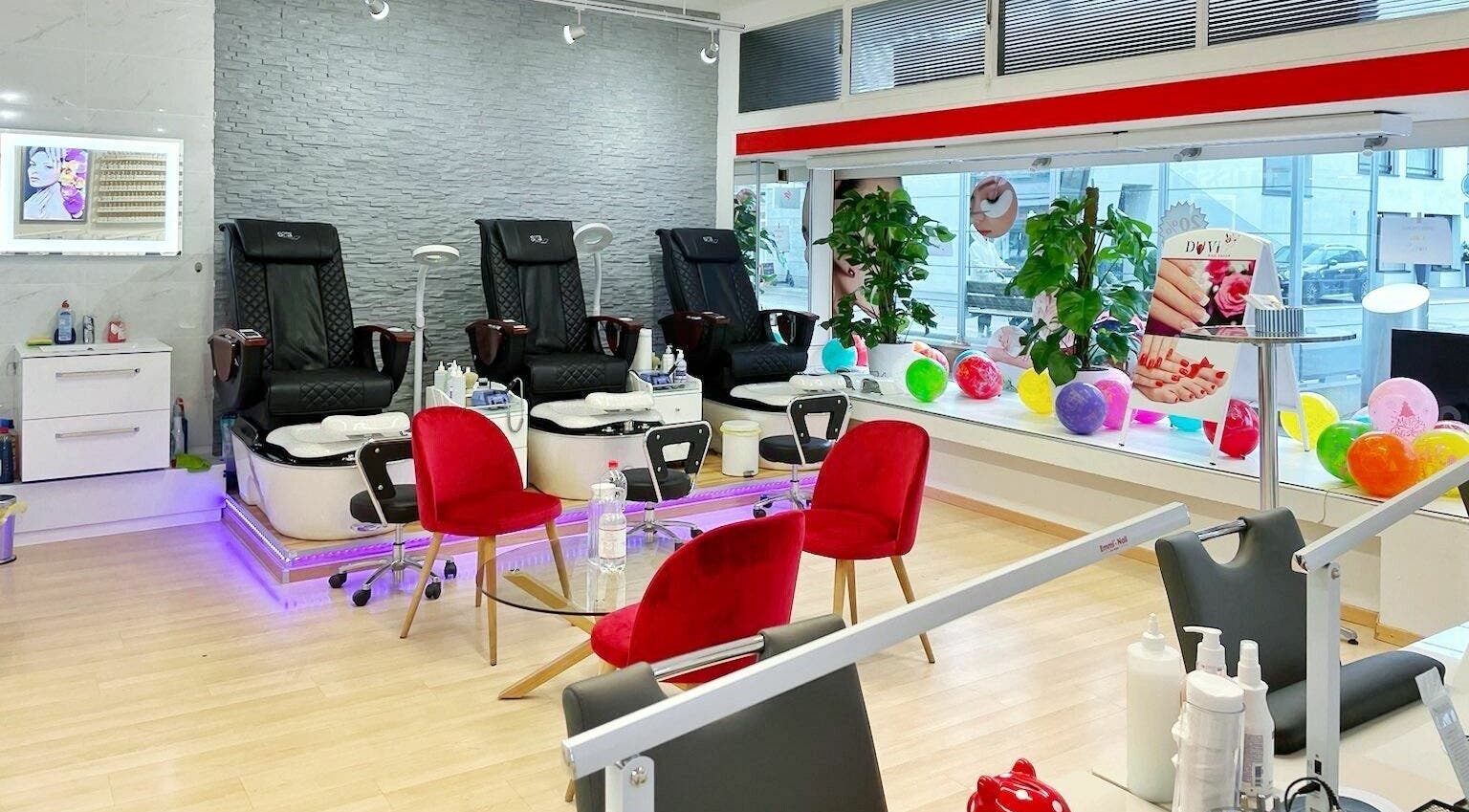 Bright interior of Duvi Nails Salon - Zurich showcases luxurious nail spa chairs and red accents, Zürich, Zürich, CH.
