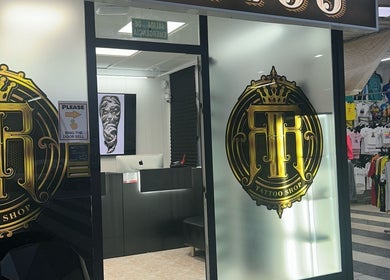Fachada de Rr Tattoo & Piercing Studio en Benidorm, Comunidad Valenciana, ES, con logo dorado en la puerta.