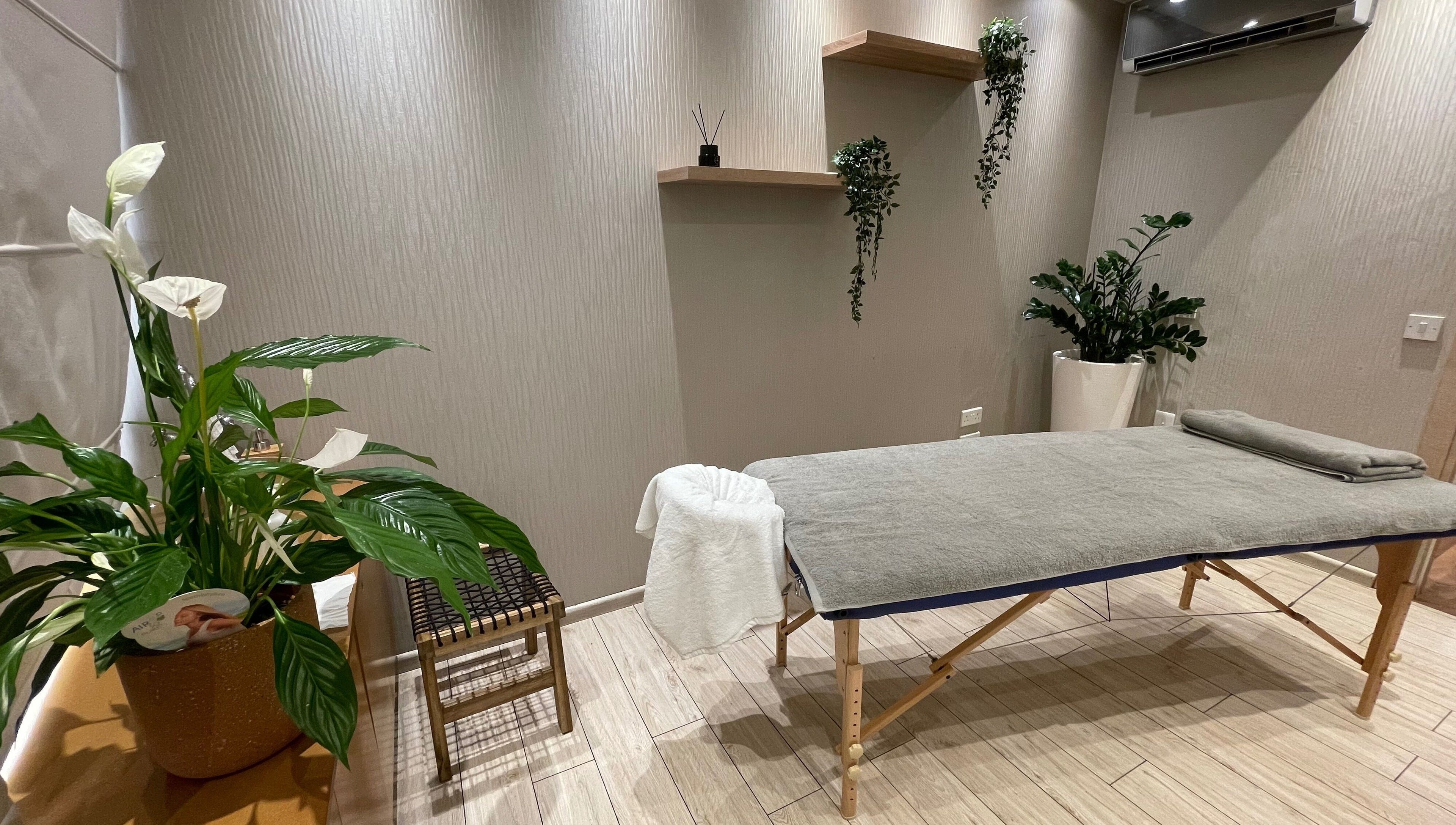 Peaceful massage room at Health First Clinic, Lemesos, Lemesos, CY with a treatment table and lush plants.