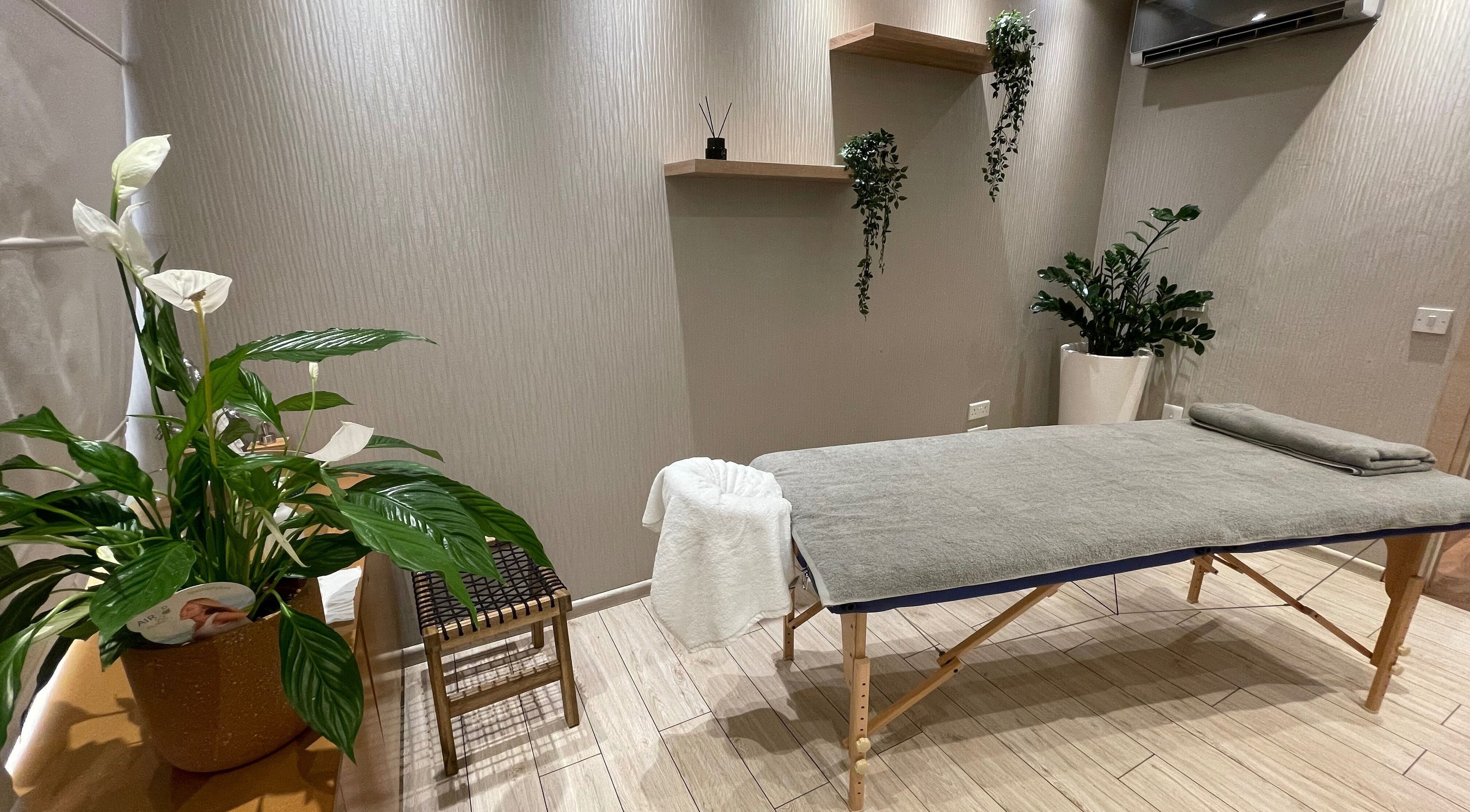 Peaceful massage room at Health First Clinic, Lemesos, Lemesos, CY with a treatment table and lush plants.