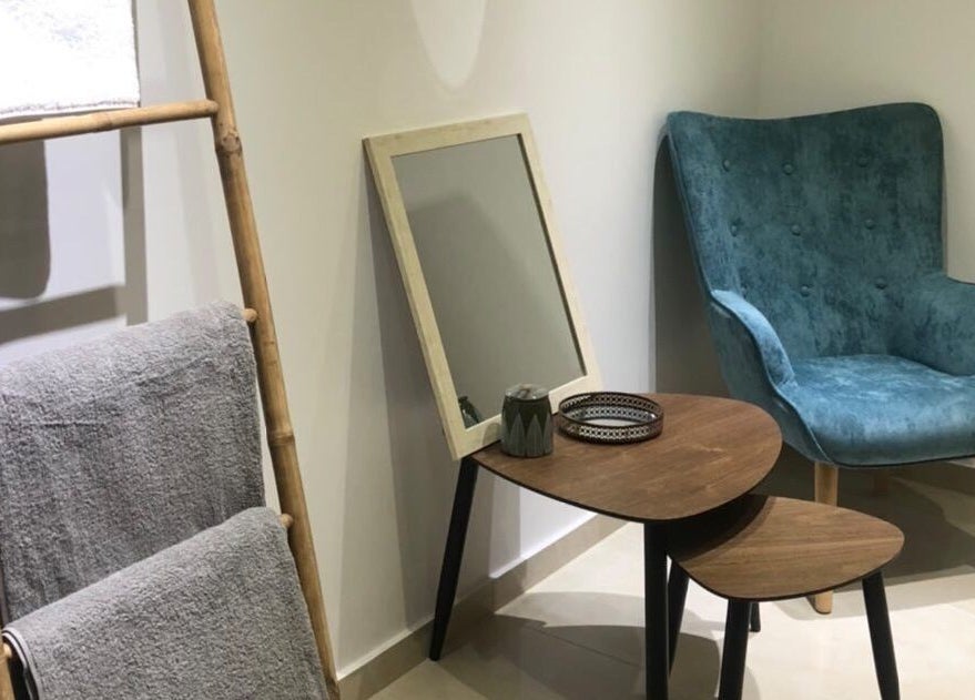 Relaxing lounge at Health First Clinic, Lemesos, Lemesos, CY with plush chair and decorative ladder.