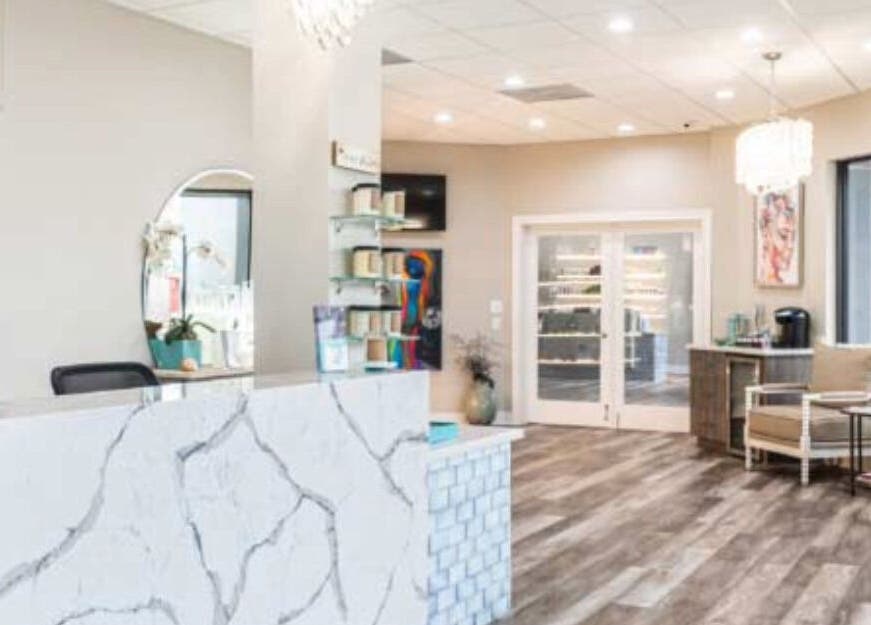 Elegant reception area at The Beaute Compound in The Woodlands, Texas, US, featuring marble surfaces and warm lighting.
