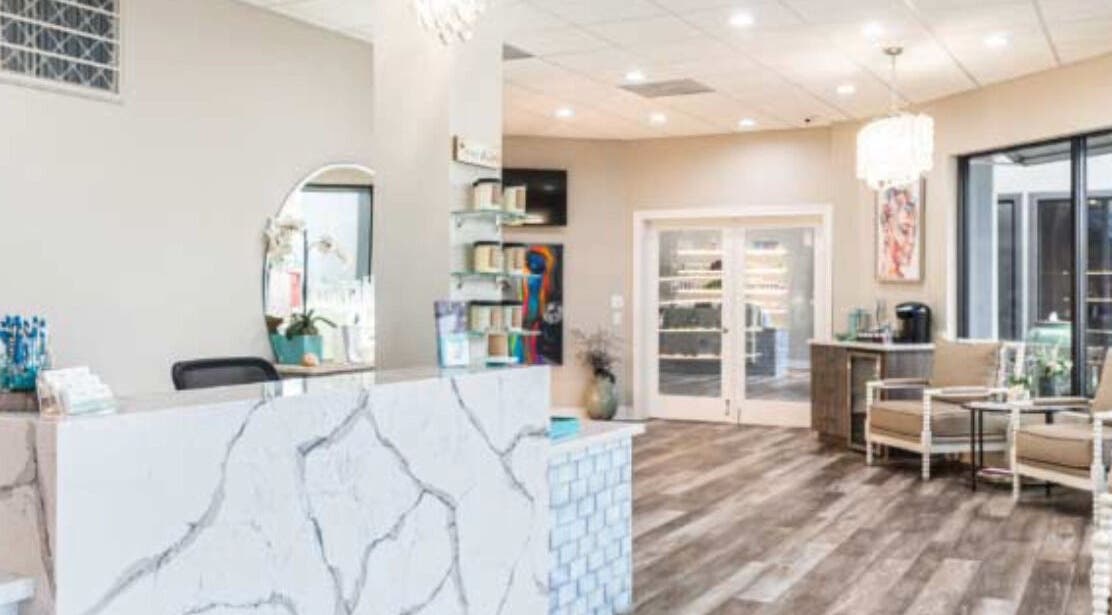 Elegant reception area at The Beaute Compound in The Woodlands, Texas, US, featuring marble surfaces and warm lighting.