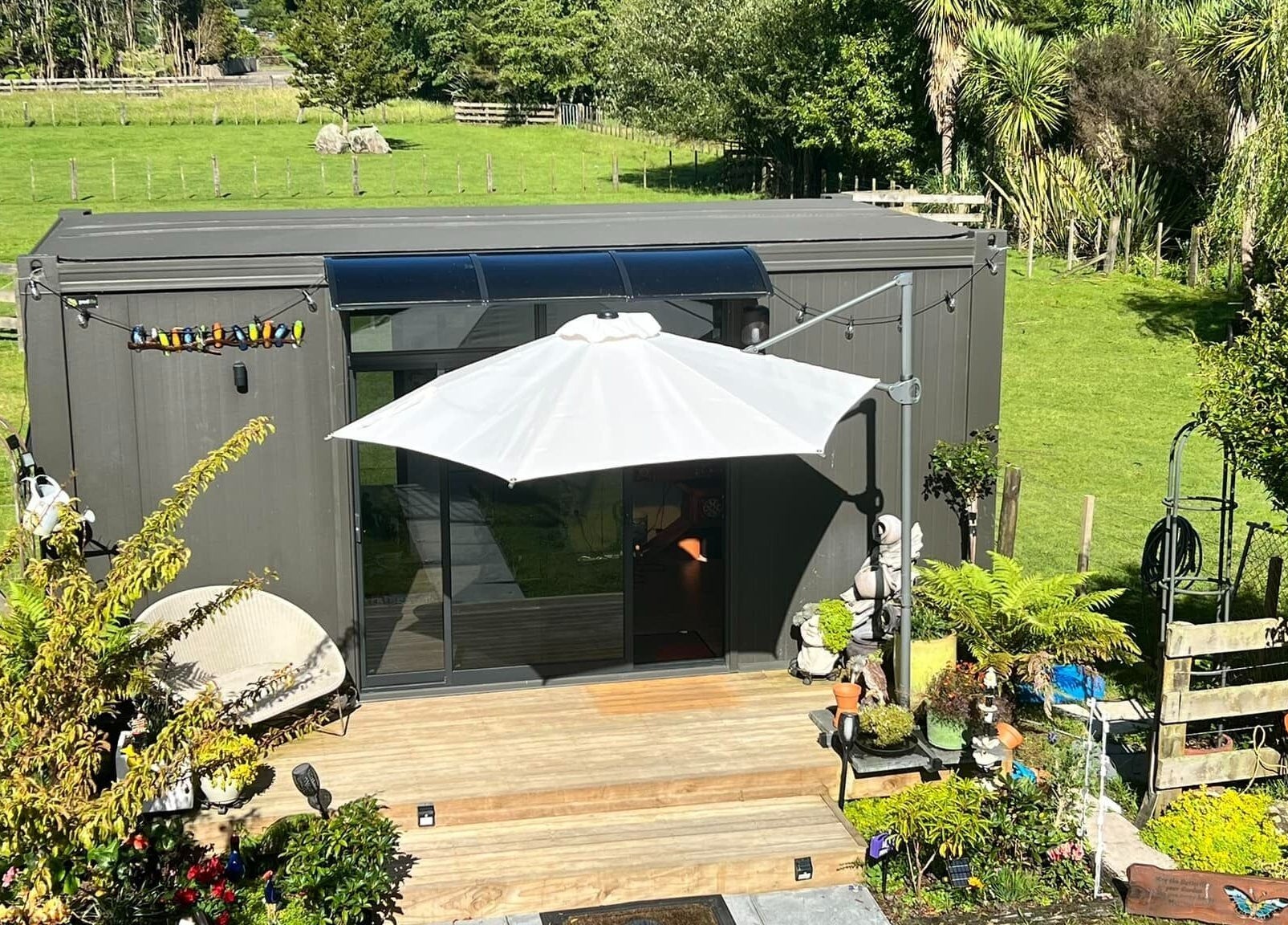 Peaceful garden setting at Kaska Kuts Barber, Hamurana, Bay of Plenty, NZ, showcasing lush greenery and cozy seating.