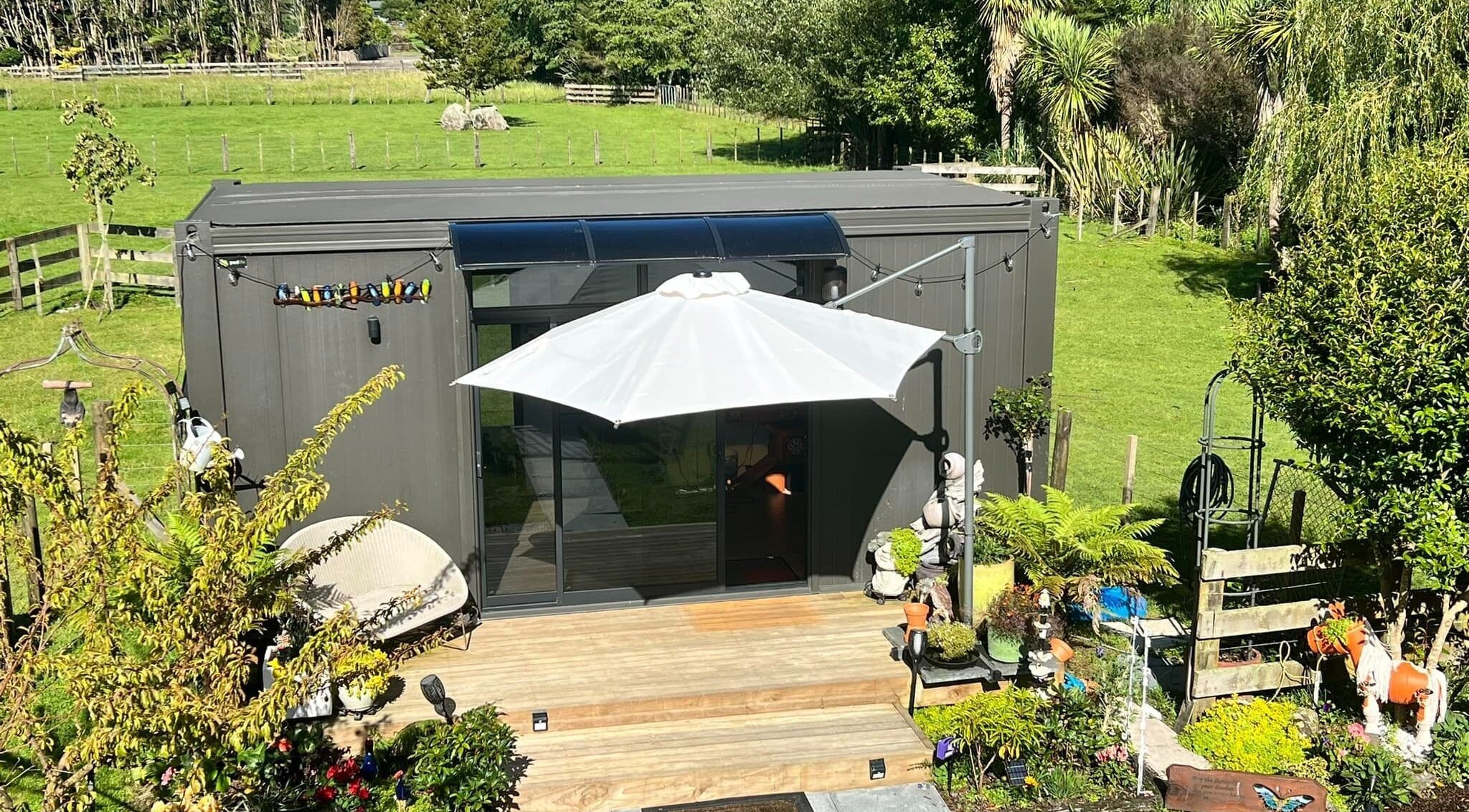 Peaceful garden setting at Kaska Kuts Barber, Hamurana, Bay of Plenty, NZ, showcasing lush greenery and cozy seating.