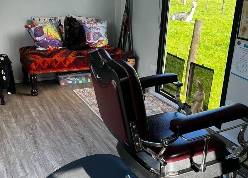 Cozy interior of Kaska Kuts Barber in Hamurana, Bay of Plenty, NZ, with vintage chair and colorful decor.
