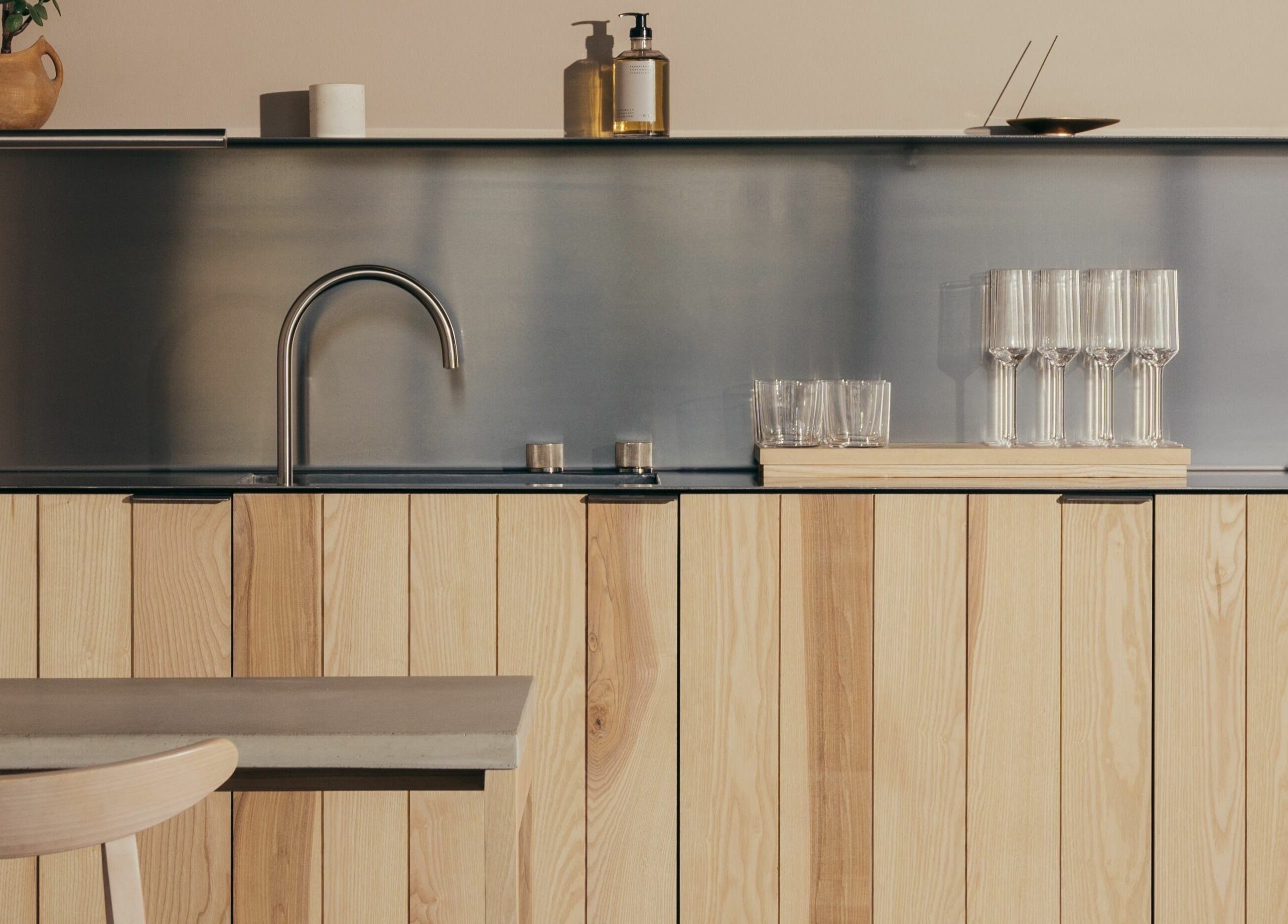 Modern kitchen interior at Buff Concept Store, Edinburgh, Scotland, GB, featuring sleek wooden cabinetry and glassware.