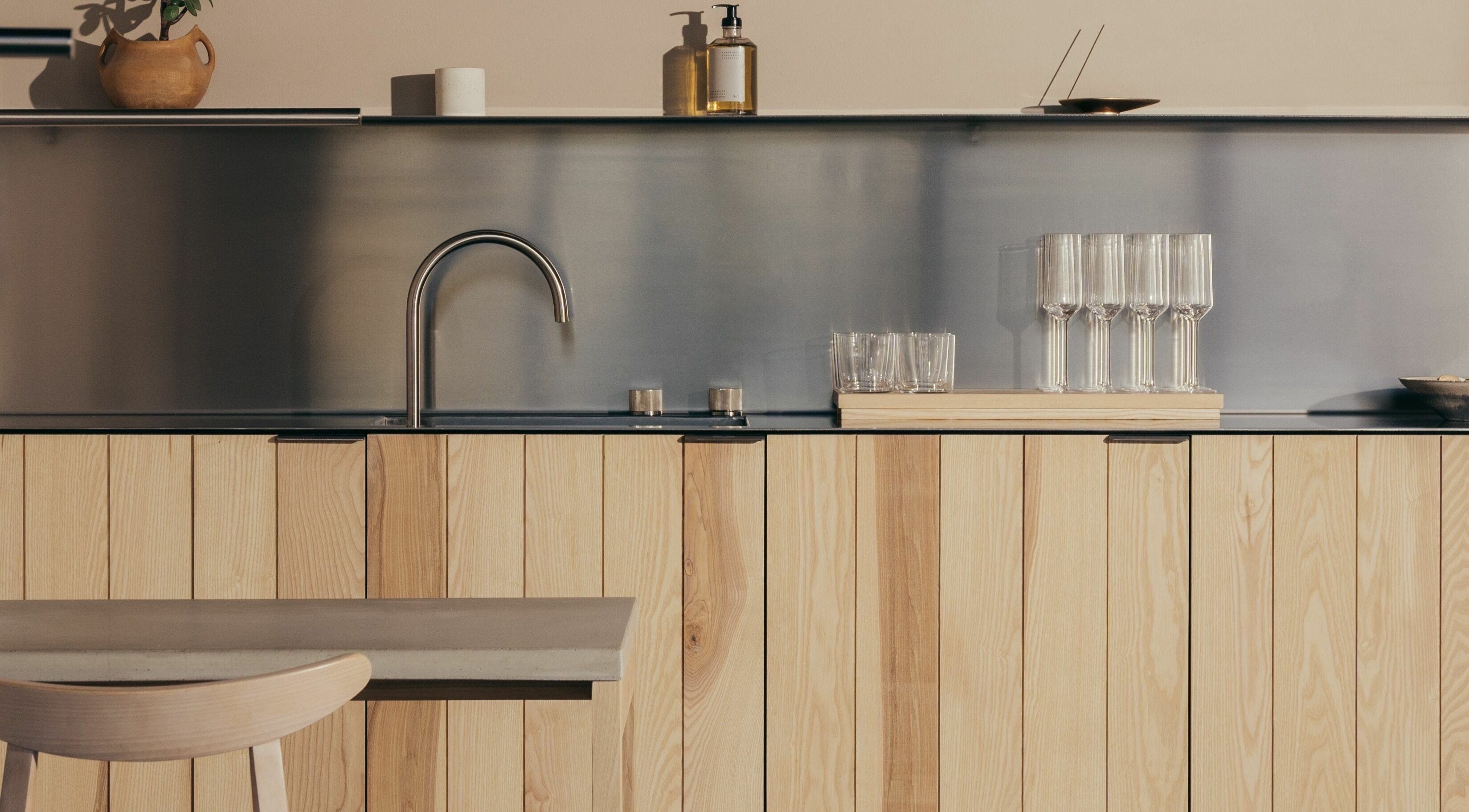 Modern kitchen interior at Buff Concept Store, Edinburgh, Scotland, GB, featuring sleek wooden cabinetry and glassware.
