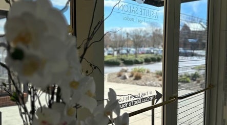 Entrance of Colored by Megan in Charlotte, North Carolina, US with glass doors and floral decor.