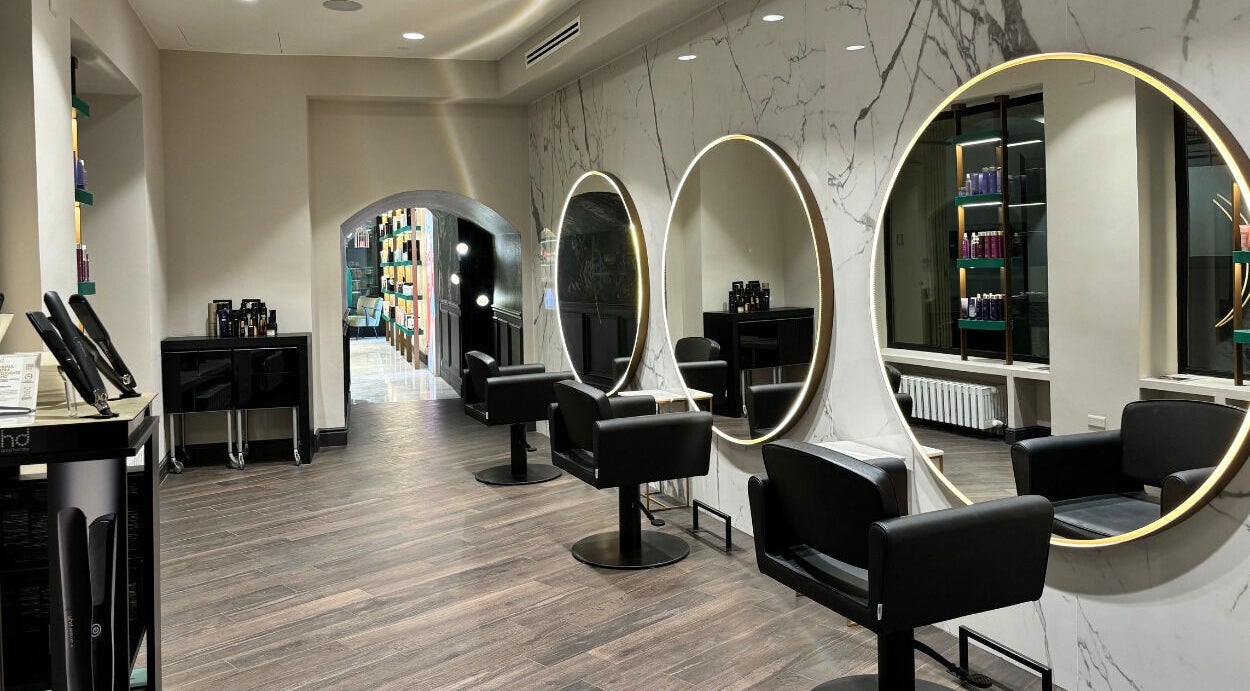 Interno raffinato di Encapture Hair Salon More a Como, Lombardia, IT con specchi e arredi moderni.
