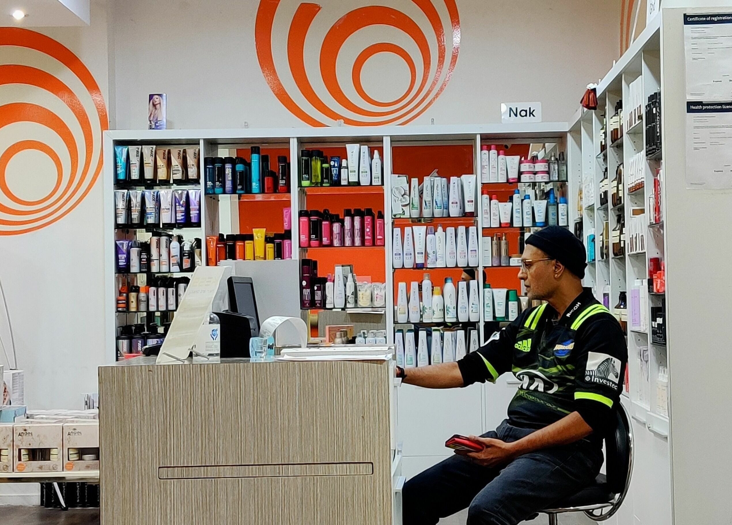 Inside Kess Hair & Beauty St. Lukes, Auckland, NZ, showcasing vibrant product shelves and customer area.