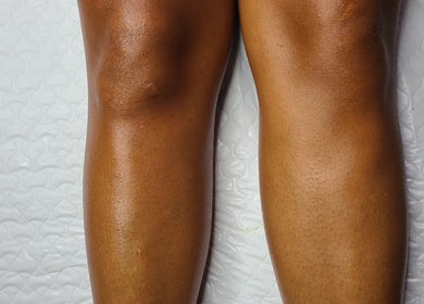 Smooth, moisturized legs showcased on a white quilt at Necessities Beauty Studio, Mandeville, Manchester Parish, JM.