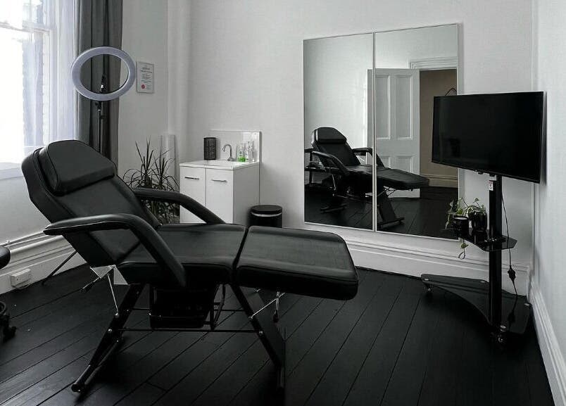 Modern treatment room at Inkd SMP in Melbourne, Victoria, AU, featuring sleek furniture and ambient lighting.