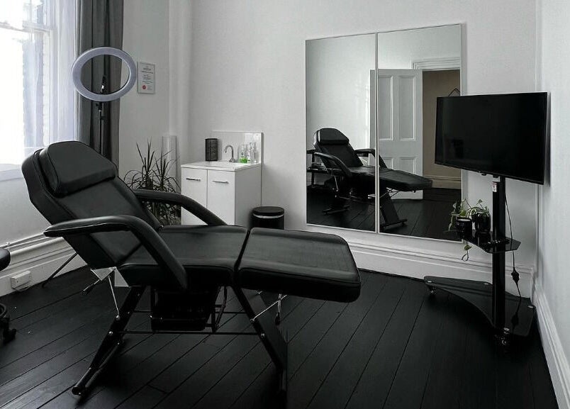 Modern treatment room at Inkd SMP in Melbourne, Victoria, AU, featuring sleek furniture and ambient lighting.