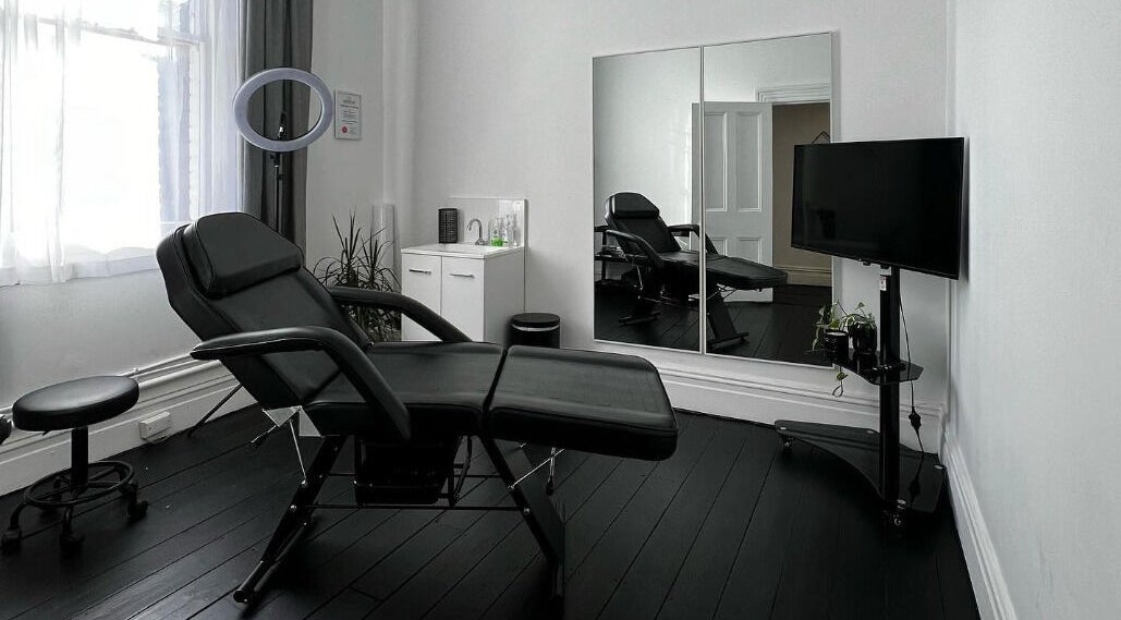 Modern treatment room at Inkd SMP in Melbourne, Victoria, AU, featuring sleek furniture and ambient lighting.