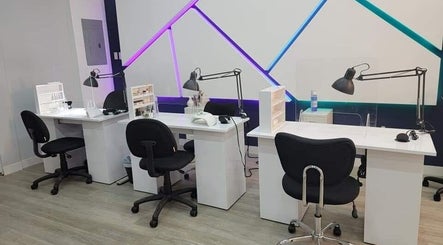 Modern nail stations at Beautique by Genesis, Mayagüez, PR, with sleek chairs and vibrant lighting.