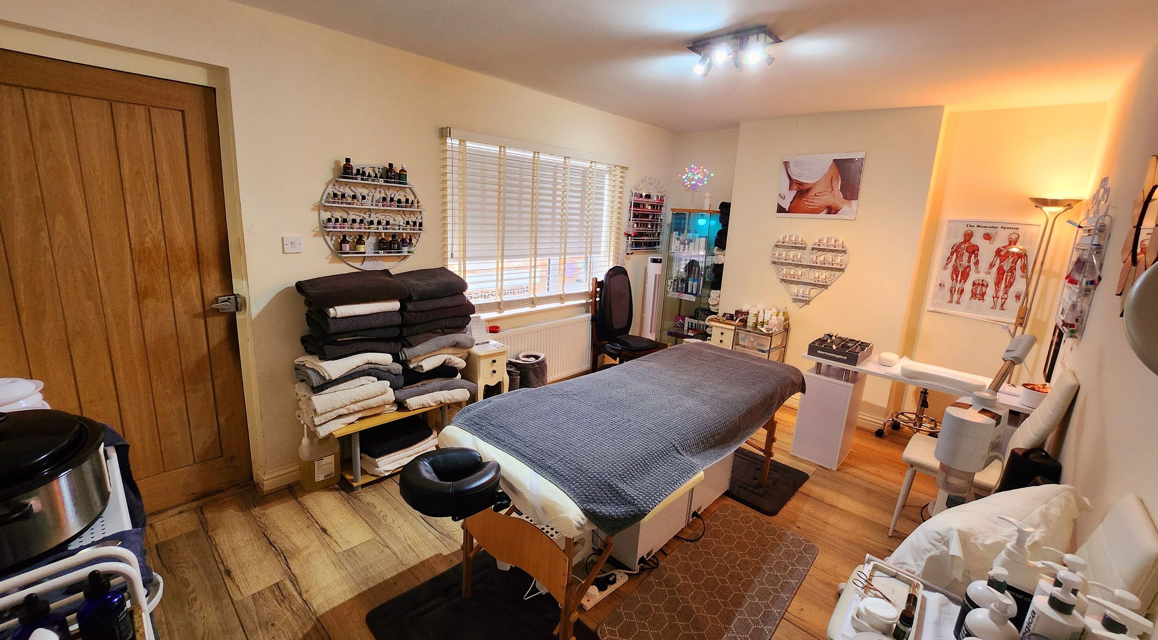 Relaxing spa room at Castaway Beauty in Ducklington, England, GB with massage table and warm lighting.