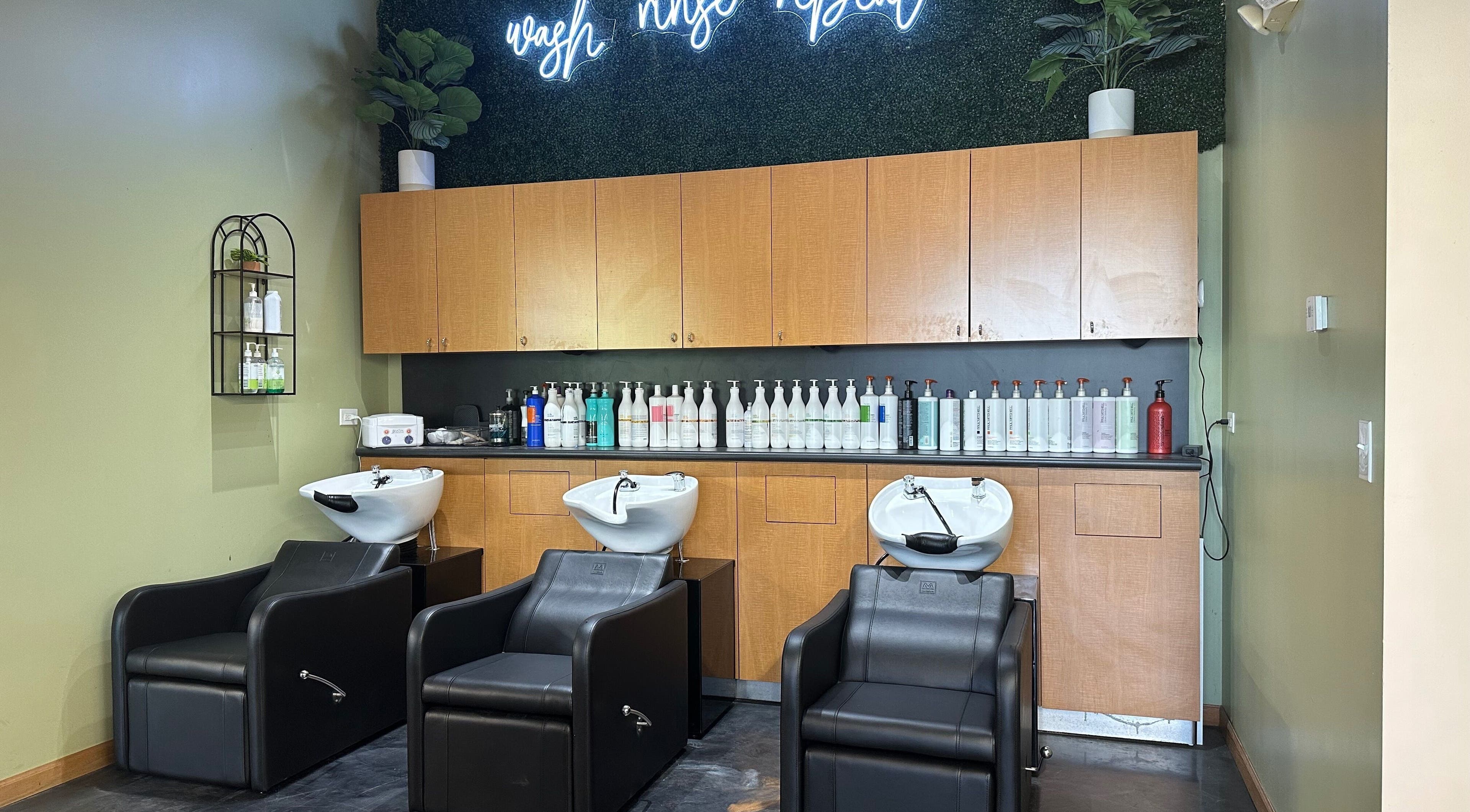 Chic salon wash station at Fantastic Sams, New Lenox, Illinois, US, with modern black chairs and stylish décor.
