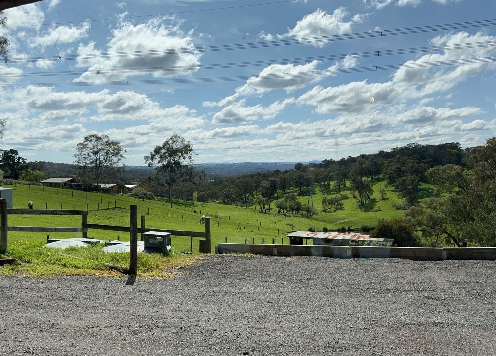 View of lush green fields near Casey’s Hair Studio, Melbourne, Victoria, AU under a bright blue sky.
