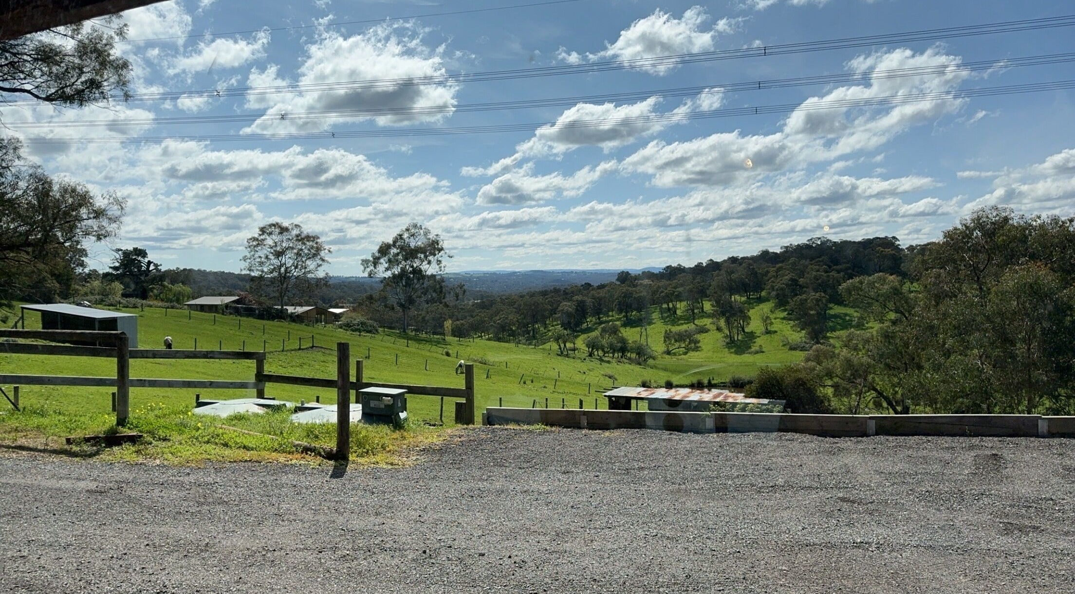 View of lush green fields near Casey’s Hair Studio, Melbourne, Victoria, AU under a bright blue sky.