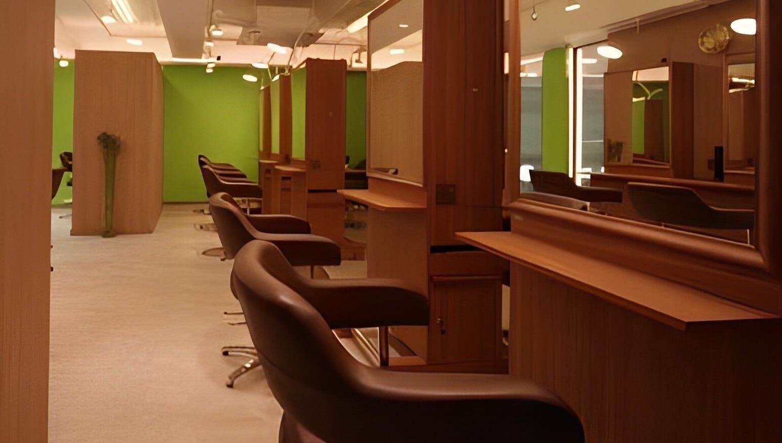 Modern salon interior at Causeway Bay Branch, Hong Kong Island, HK with sleek brown chairs and green accents.