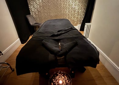 Tranquil massage room at Beauty Within, Gosport, England, GB, featuring a cozy black treatment table and calming decor.