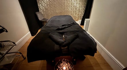 Tranquil massage room at Beauty Within, Gosport, England, GB, featuring a cozy black treatment table and calming decor.