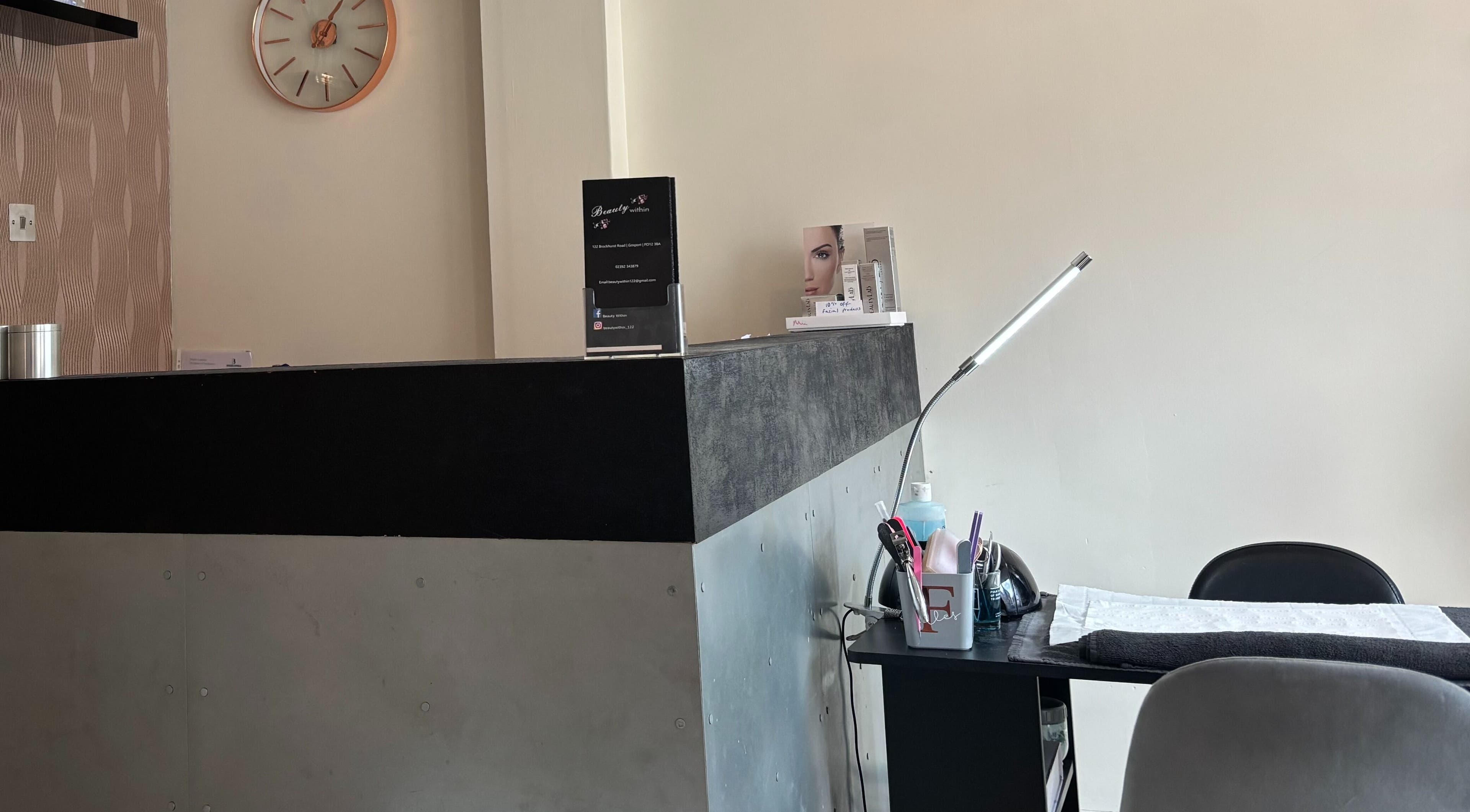 Reception area at Beauty Within, Gosport, England, GB with sleek desk and decor.