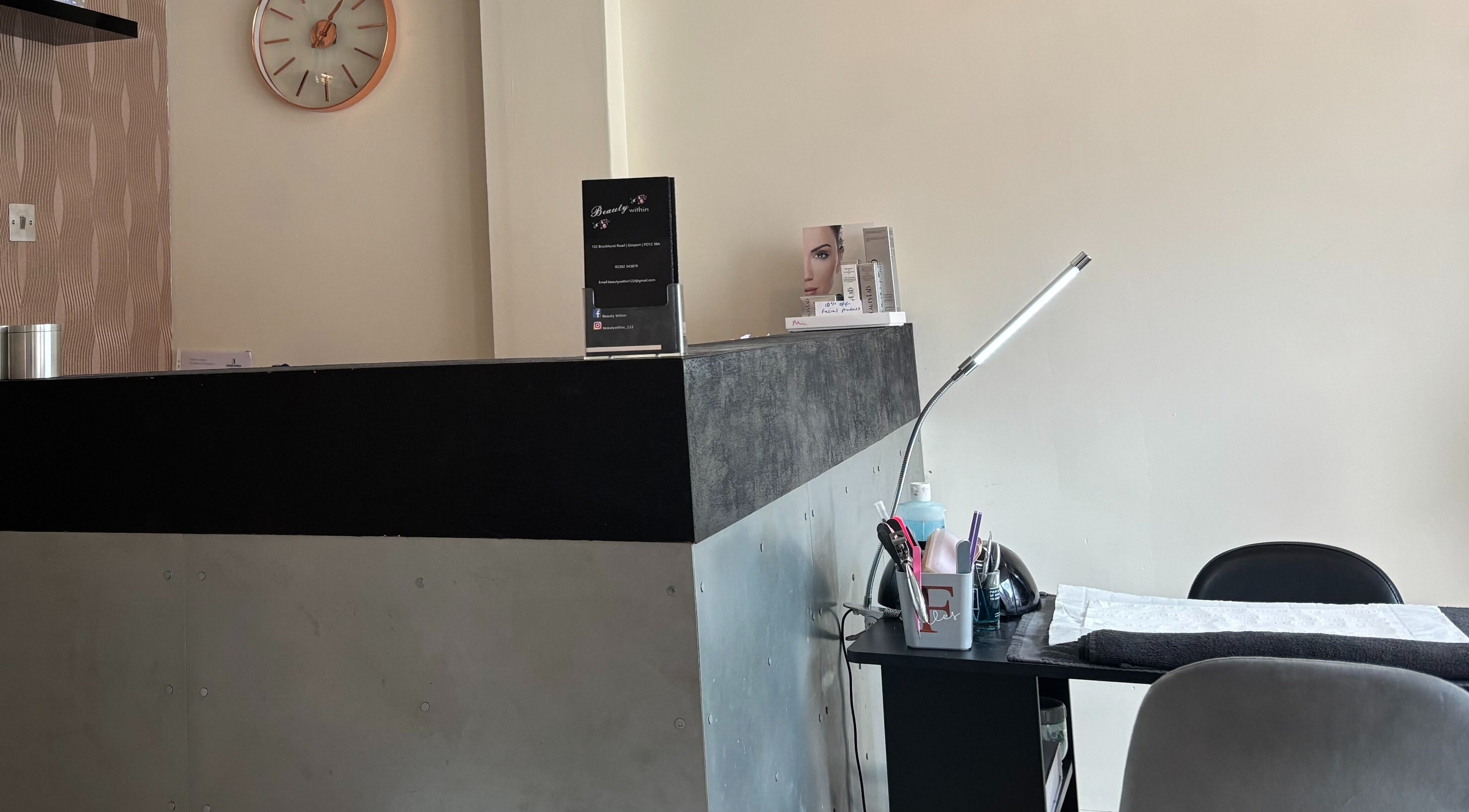Reception area at Beauty Within, Gosport, England, GB with sleek desk and decor.